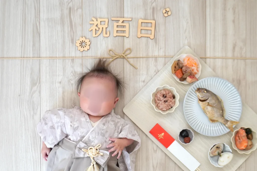 和装を着た赤ちゃんとお食い初め膳を並べた百日祝のおしゃれな写真
