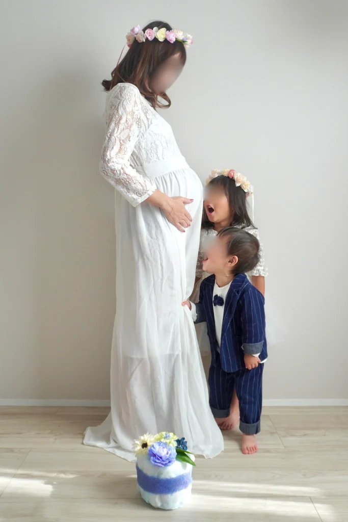 姉と兄がお腹に声をかけているマタニティフォト