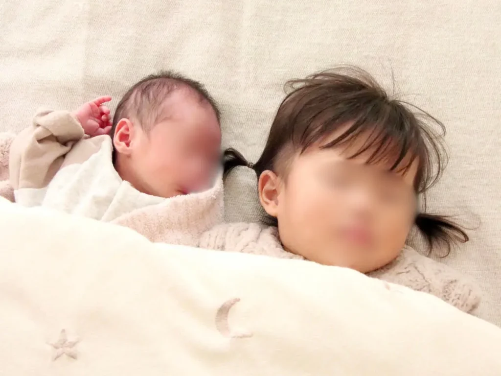 新生児と2歳お姉ちゃんが横並びで寝ている写真