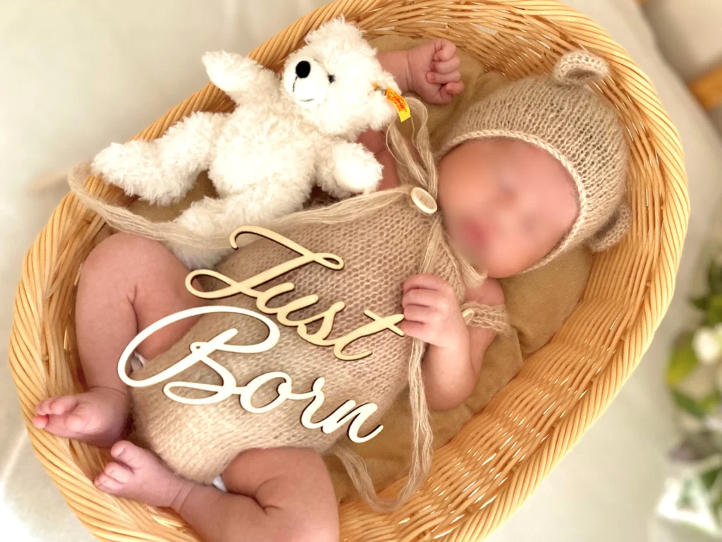 カゴと木製装飾を使ったニューボーンフォトの写真