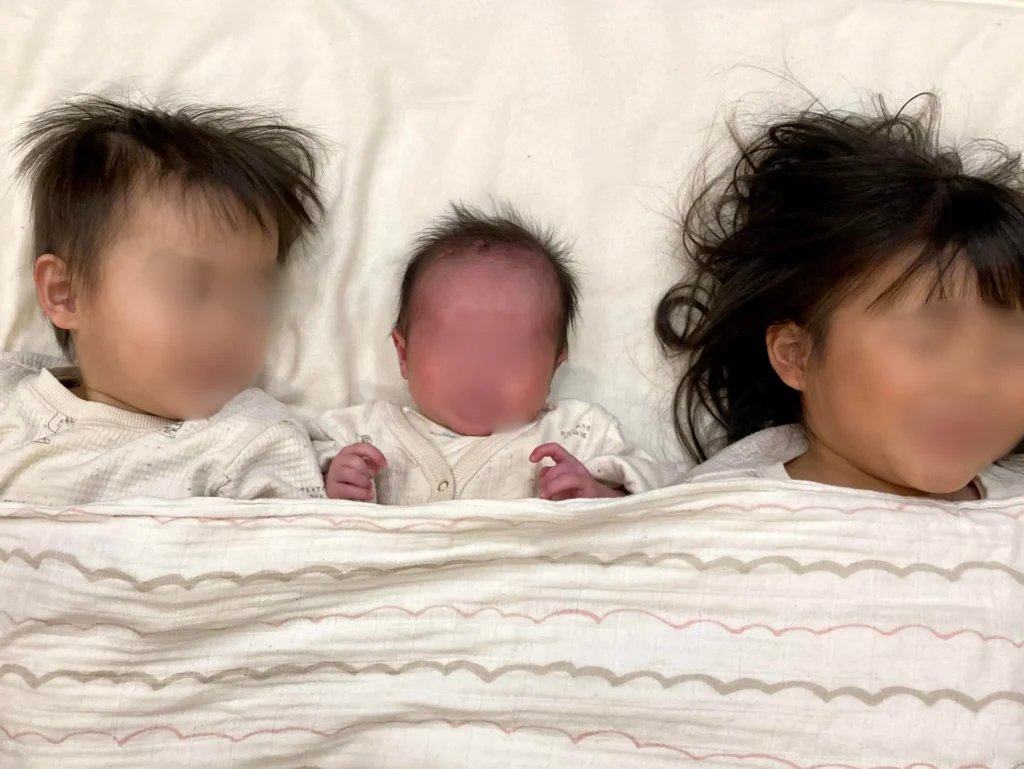 新生児と2歳お兄ちゃんと4歳のお姉ちゃんが横並びで寝ている写真